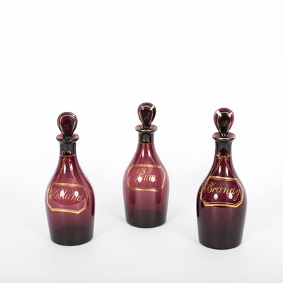 Lot 496 - Three amethyst glass decanters and stoppers