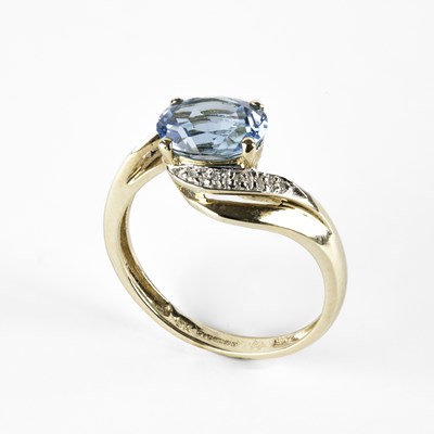 Lot 326 - A 9ct yellow gold blue topaz and diamond crossover ring
