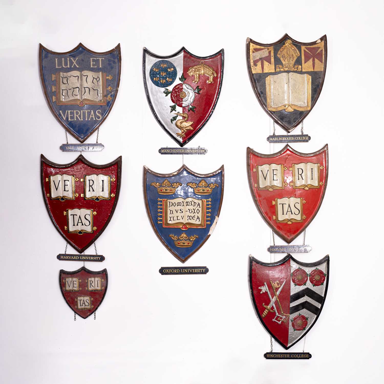 Lot 5 - A collection of painted plaster university heraldic shields