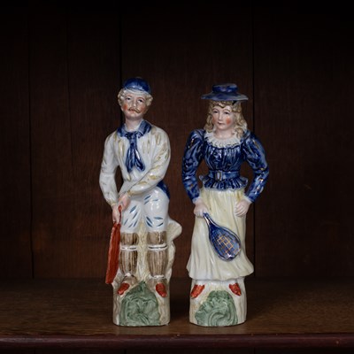 Lot 175 - A pair of Continental porcelain models of a cricketer and tennis player companion