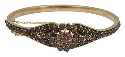 Lot 647 - A Victorian yellow metal garnet hinged bangle