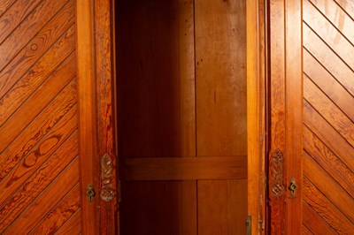 Lot 348 - An Aesthetic movement pitch pine triple wardrobe